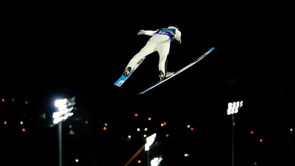 Domen Prevc, of Slovenia, soars through the air during his first round jump of the ski jumping men's super team competition at the 2026 Winter Olympics, in Predazzo, Italy, Monday, Feb. 16, 2026. (AP Photo/Matthias Schrader)