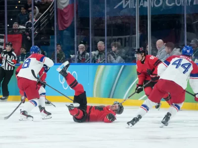 Canada's Sidney Crosby (87) falls after being checked by Czechia's Ondrej Palat (18) during the second period of a men's ice hockey quarterfinal game at the 2026 Winter Olympics, in Milan, Italy, Wednesday, Feb. 18, 2026. (Darryl Dyck/The Canadian Press via AP)