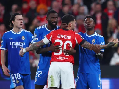 Soccer Football - UEFA Champions League - Play Off - First Leg - Benfica v Real Madrid - Estadio da Luz, Lisbon, Portugal - February 17, 2026 Real Madrid's Vinicius Junior, Alvaro Carreras and Antonio Rudiger clash with Benfica's Nicolas Otamendi REUTERS/Pedro Nunes