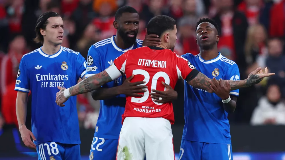 Soccer Football - UEFA Champions League - Play Off - First Leg - Benfica v Real Madrid - Estadio da Luz, Lisbon, Portugal - February 17, 2026 Real Madrid's Vinicius Junior, Alvaro Carreras and Antonio Rudiger clash with Benfica's Nicolas Otamendi REUTERS/Pedro Nunes