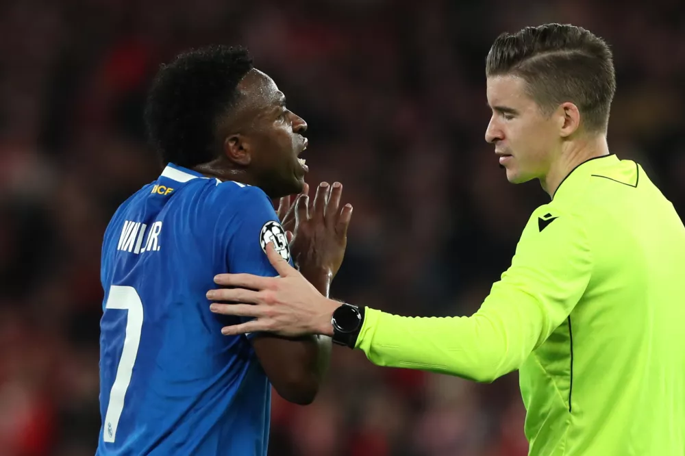 Real Madrid's Vinicius Junior argues with referee Fran&ccedil;ois Letexier after scoring the opening goal during a Champions League playoff soccer match between SL Benfica and Real Madrid in Lisbon, Portugal, Tuesday, Feb. 17, 2026. (AP Photo/Pedro Rocha)