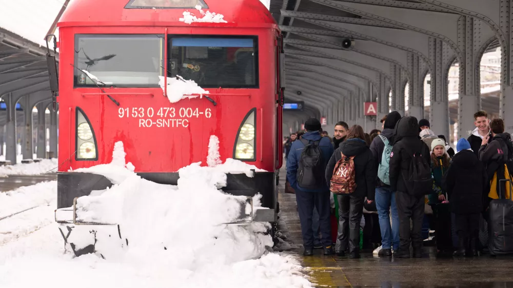 Passengers wait next to a snow covered train engine at the Gara de Nord railway station, after a blizzard in Bucharest, Romania, Wednesday, Feb. 18, 2026. (AP Photo/Vadim Ghirda)