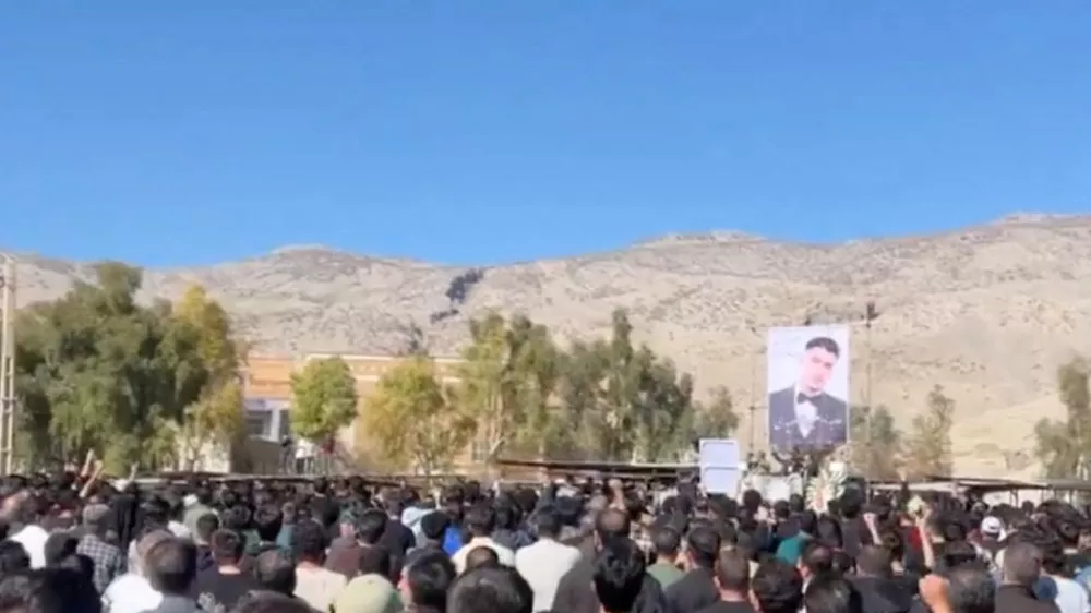 People stand facing the portrait of a deceased person as they gather at a cemetery in Abdanan, Ilam Province, Iran, in this screengrab taken from a social media video released February 17, 2026. Social media via RUTERS THIS IMAGE HAS BEEN SUPPLIED BY A THIRD PARTY. NO RESALES. NO ARCHIVES