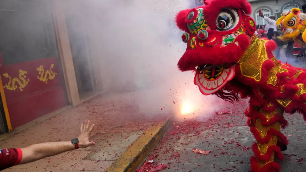 People perform a lion dance and throw fireworks to celebrate the Lunar New Year in Panama City, Tuesday, Feb. 17, 2026. (AP Photo/Matias Delacroix)