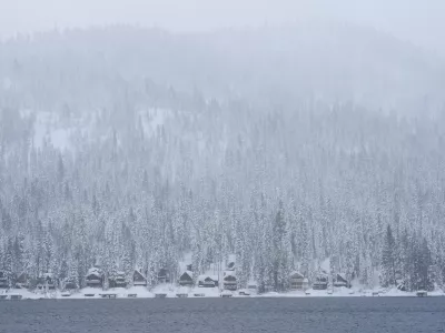 Snow comes down on a forest and cabins along Donner Lake during a storm Thursday, Feb. 19, 2026, near Truckee, Calif. (AP Photo/Godofredo A. V&aacute;squez)