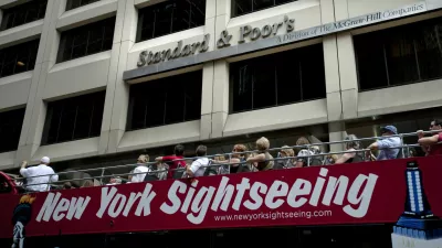 FILE - In this Aug. 6, 2011 photo, tourists drive past Standard & Poor's headquarters in New York's financial district Saturday, Aug. 6, 2011. (AP Photo/Karly Domb Sadof, File)