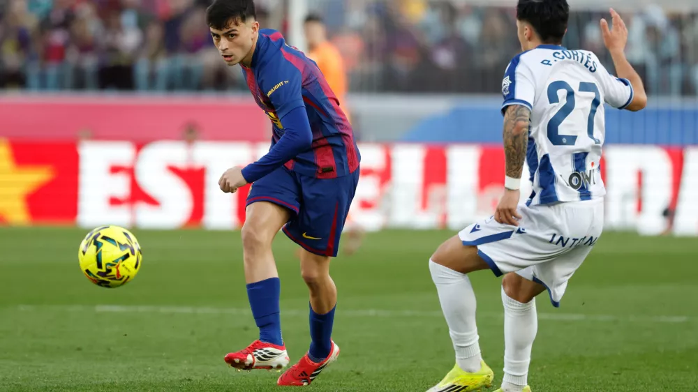 Barcelona's Pedri passes the ball by Levante's Paco Cortes during a La Liga soccer match between Barcelona and Levante in Barcelona, Spain, Sunday, Feb. 22, 2026. (AP Photo/Joan Monfort)