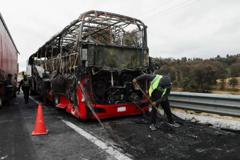 A burnt bus stands at the site on the highway connecting Mexico City with the state of Puebla, following roadblocks and arson attacks carried out by members of organized crime in several states after a military operation in which a government source said Mexican drug lord Nemesio Oseguera, known as "El Mencho," was killed in Jalisco state, in Santa Rita Tlahuapan, Mexico, February 22, 2026. REUTERS/Paola Garcia