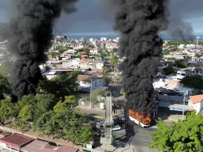 Smoke billows from burning vehicles amid a wave of violence, with torched vehicles and gunmen blocking highways in more than half a dozen states, following a military operation in which a government source said Mexican drug lord Nemesio Oseguera, known as "El Mencho," was killed, in Puerto Vallarta, Jalisco, Mexico, February 22, 2026, in this screen grab obtained from a social media video. @morelifediares via Instagram/Youtube/via REUTERS THIS IMAGE HAS BEEN SUPPLIED BY A THIRD PARTY. MANDATORY CREDIT. NO RESALES. NO ARCHIVES. TPX IMAGES OF THE DAY Verification: Reuters confirmed the location as Puerto Vallarta by the road layout, trees, buildings and businesses logos which matched file and satellite imagery. The shape of the mountains matched topography mapping. The date when the videos were filmed was verified by original file metadata.