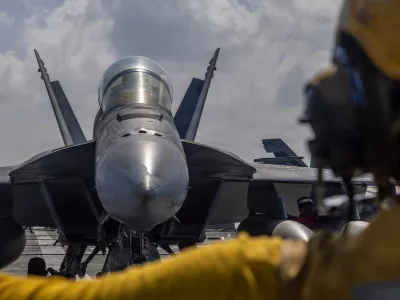 This handout photograph from the U.S. Navy shows Aviation Boatswain's Mate 2nd Class Michael Cordova directing an F/A-18F Super Hornet on the flight deck of the Nimitz-class aircraft carrier USS Abraham Lincoln in the Indian Ocean on Jan. 23, 2026. (Mass Communication Specialist Seaman Daniel Kimmelman/U.S. Navy via AP)