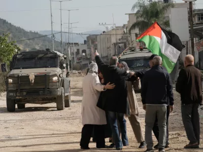 Displaced Palestinians gather during a protest calling to return to their houses in the Nur Shams refugee camp, in the West Bank city of Tulkarem, Monday, Dec. 15, 2025. (AP Photo/Majdi Mohammed)