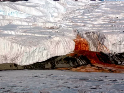 The Blood Falls seeps from the end of the Taylor Glacier into Lake Bonney. The tent at left provides a sense of scale for just how big the phenomenon is. Scientists believe a buried saltwater reservoir is partly responsible for the discoloration, which is a form of reduced iron.
