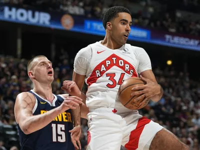 FILE - Toronto Raptors center Jontay Porter, right, pulls in a rebound as Denver Nuggets center Nikola Jokic, left, defends in the first half of an NBA basketball game Monday, March 11, 2024, in Denver. The NBA banned Toronto two-way player Jontay Porter on Wednesday, April 17, 2024, after a league probe found he disclosed confidential information to sports bettors and bet on games.(AP Photo/David Zalubowski, File)