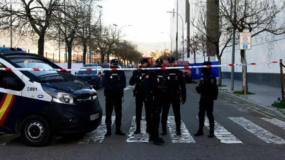 Spanish police officers stand behind a security cordon near the City of Justice building, which is being used as a morgue, following the deadly derailment of two high-speed trains near Adamuz, in Cordoba, Spain, January 20, 2026. REUTERS/Jon Nazca