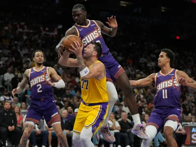 Los Angeles Lakers guard Luka Doncic drives between Phoenix Suns guard Amir Coffey (2), center Khaman Maluach, and forward Oso Ighodaro (11) during the second half of an NBA basketball game, Thursday, Feb. 26, 2026, in Phoenix. (AP Photo/Rick Scuteri)