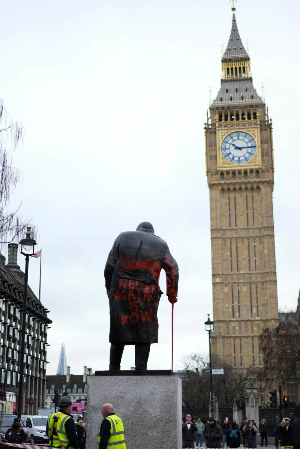 Workers stand next to the statue of Sir Winston Churchill, which was defaced overnight with red paint and the words "Never again is now", in Parliament Square, London, Britain, February 27, 2026. REUTERS/Carlos Jasso