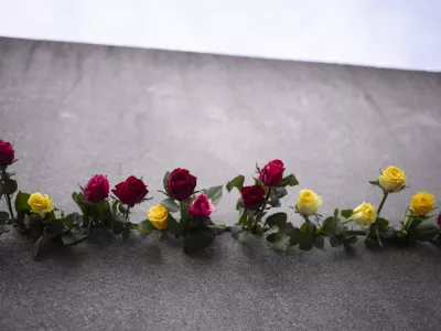 Flowers pile up in a crack in the Berlin Wall for the victims of the German division during an event to mark the 34th anniversary of the fall of the Berlin Wall at the Berlin Wall Memorial, Thursday, Nov. 9, 2023. (AP Photo/Markus Schreiber) / Foto: Markus Schreiber
