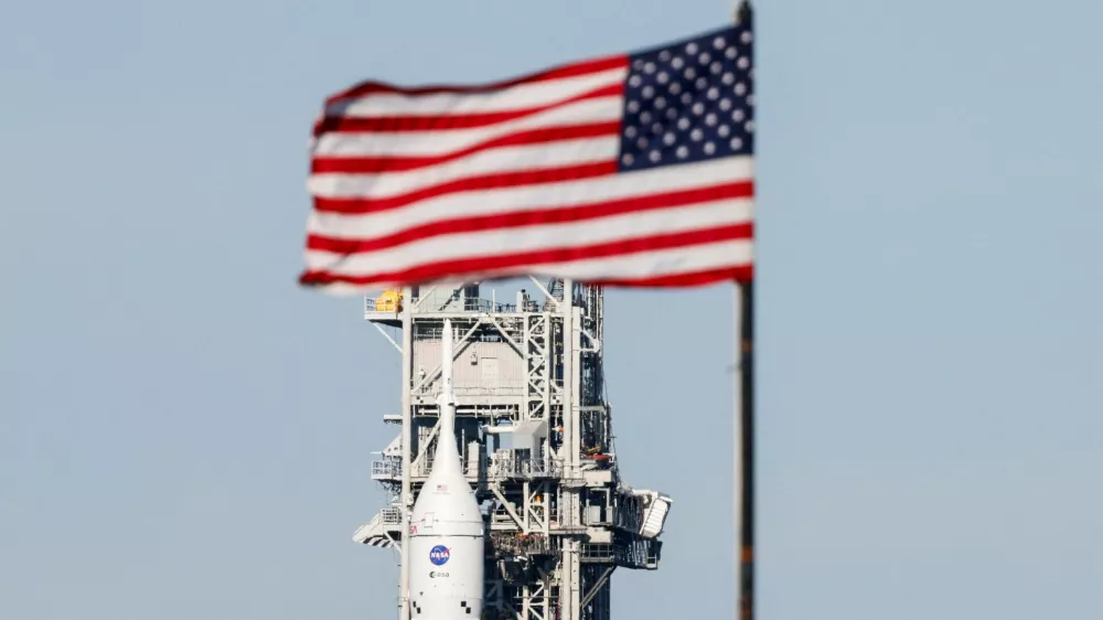 NASA's next-generation moon rocket, the Space Launch System (SLS) rocket with the Orion crew capsule, rolls from its launch pad back to the Vehicle Assembly Building for repairs ahead of the Artemis II mission launch at the Kennedy Space Center in Cape Canaveral, Florida, U.S., February 25, 2026. The capsule is behind the press site flag. Launch is scheduled no earlier than April 1, 2026. REUTERS/Joe Skipper