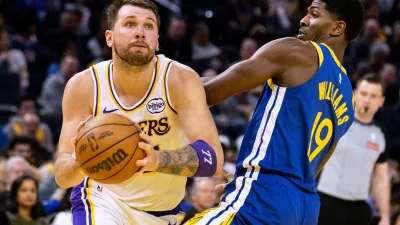 Los Angeles Lakers guard Luka Doncic (77) drives past Golden State Warriors guard Nate Williams (19) during the third quarter of their NBA basketball game in San Francisco Saturday, Feb. 28, 2026. (Stephen Lam/San Francisco Chronicle via AP)