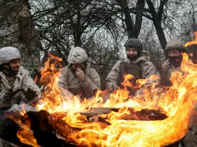 Recruits of the 28th Separate Mechanized Brigade of the Armed Forces of Ukraine warm themselves by the fire during a military exercise before combat missions, amid Russia's attack on Ukraine, in Kharkiv region, Ukraine February 26, 2026. REUTERS/Sofiia Gatilova
