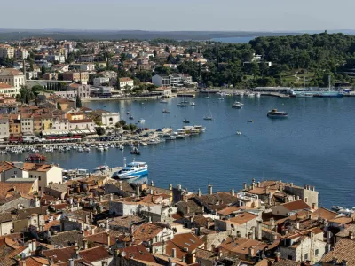 Rovinj; Croatia; Istria - September 29; 2023: Aerial view from bell tower of Saint Euphemia Church of port with moored boats. Typical red ceramic roof tile