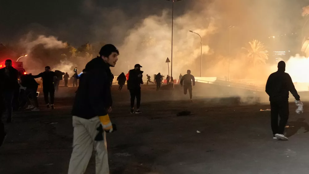 Security forces fire tear gas to disperse a protest against U.S. and Israeli attacks on Iran, at a bridge leading to the fortified Green Zone where the U.S. Embassy is located, in Baghdad, Iraq, Monday, March 2, 2026. (AP Photo/Hadi Mizban)