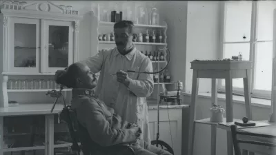 Oficir pri zobozdravniku med prvo svetovno vojno. Naglič je, čeprav je bil zaprt na Ljubljanskem gradu v karantenski postaji, začuda lahko prosto fotografiral in tako ohranil edinstvene prizore voja&scaron;kega vsakdana. / Foto: Peter Naglič