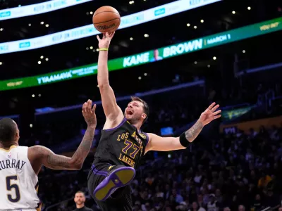 Los Angeles Lakers guard Luka Doncic, right, shoots as New Orleans Pelicans guard Dejounte Murray defends during the second half of an NBA basketball game Tuesday, March 3, 2026, in Los Angeles. (AP Photo/Mark J. Terrill)