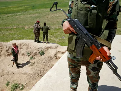 Yazidi female fighter Asema Dahir (R), 21, holds a weapon during a deployment near the frontline of the fight against Islamic State militants in Nawaran near Mosul, Iraq, April 20, 2016. When Islamic State swept into the northern Iraqi town of Sinjar in 2014, a few young Yazidi women took up arms against the militants attacking women and girls from their community. The killing and enslaving of thousands from Iraq's minority Yazidi community focused international attention on the group's violent campaign to impose its radical ideology and prompted Washington to launch an air offensive. It also prompted the formation of this unusual 30-woman unit made up of Yazidis as well as Kurds from Iraq and neighbouring Syria. For them, only one thing matters: revenge for the women raped, beaten and executed by the jihadist militants. REUTERS/Ahmed Jadallah SEARCH "WOMEN NAWARAN" FOR THIS STORY. SEARCH "THE WIDER IMAGE" FOR ALL STORIES