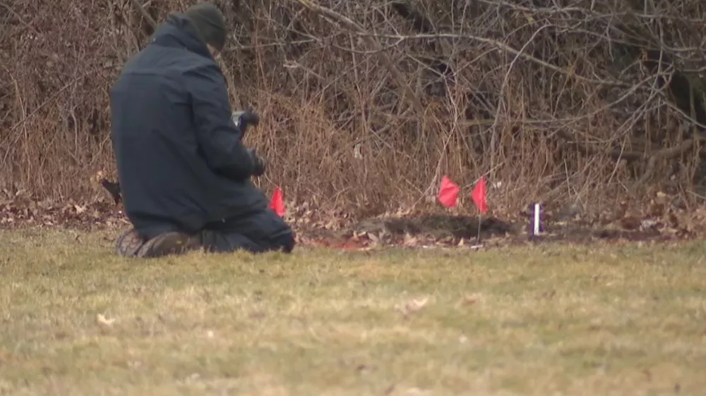 This image made from video provided by WEWS/News 5 shows an official examining a crime scene where the bodies of two young girls were found buried in suitcases, Tuesday, March 3, 2026, in Cleveland. (WEWS/News 5 via AP)