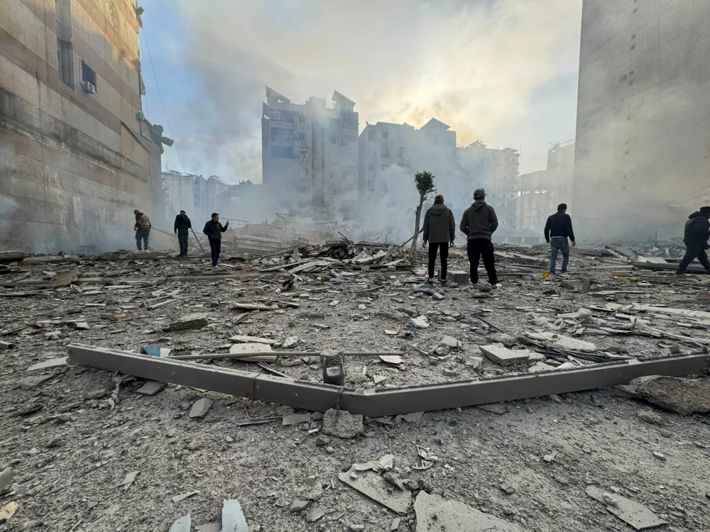 People stand on the rubble of a damaged building after an Israeli strike on Beirut's southern suburbs, following renewed hostilities between Hezbollah and Israel amid the U.S.-Israeli conflict with Iran, in Beirut, Lebanon, March 6, 2026. Picture taken with a mobile phone. REUTERS/Stringer