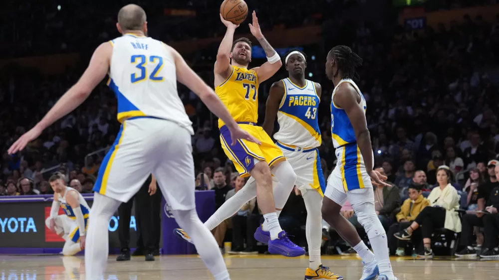 Mar 6, 2026; Los Angeles, California, USA; Los Angeles Lakers guard Luka Doncic (77) shoots the ball against Indiana Pacers forward Pascal Siakam (43), center Jay Huff (32) and guard Aaron Nesmith (23) in the first half at Crypto.com Arena. Mandatory Credit: Kirby Lee-Imagn Images