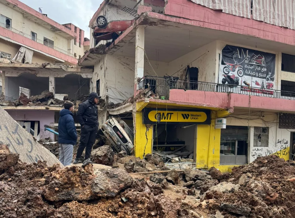 People check the damage left by Israeli airstrikes, Saturday, March 7, 2026 in the village of Nabi Chit, eastern Lebanon late Friday, where Israeli forces landed overnight and dug a grave in a cemetery searching for Israeli co-pilot Ron Arad who was captured and then went missing after his fighter jet crashed over south Lebanon in 1986. (AP Photo/Ali Salem)