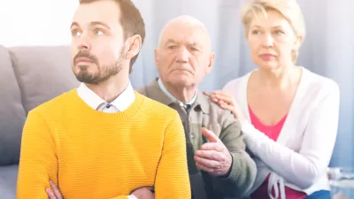 Aged grandfather teaches and instructs his young grandson in front of his mother