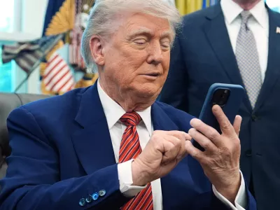 FILE - President Donald Trump silences his mobile phone in the Oval Office of the White House, May 23, 2025, in Washington. (AP Photo/Evan Vucci, File)