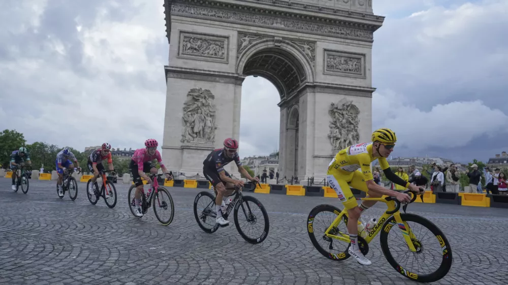 The pack with Slovenia's Tadej Pogacar, wearing the overall leader's yellow jersey, passes the Arc de Triomphe during the twenty-first stage of the Tour de France cycling race over 132.3 kilometers (82.1 miles) with start in Mantes-la-Ville and finish on the Champs-Elysees in Paris, France, Sunday, July 27, 2025. (AP Photo/Mosa'ab Elshamy)