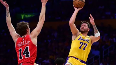 Mar 12, 2026; Los Angeles, California, USA; Los Angeles Lakers guard Luka Doncic (77) shoots against Chicago Bulls forward Matas Buzelis (14) during the first half at Crypto.com Arena. Mandatory Credit: Gary A. Vasquez-Imagn Images