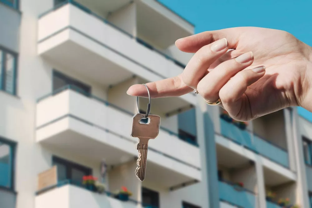 Real estate agent holding keys to new flat. Real estate, buy a home concept / Foto: Simpson33