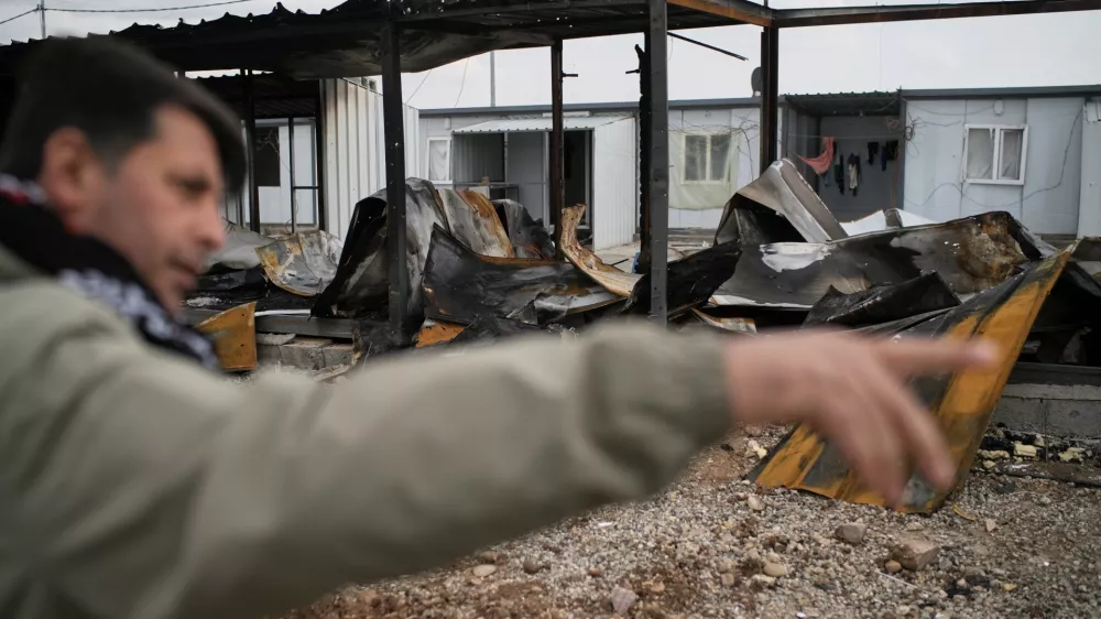 Rebaz Sharifi, a unit commander in the armed wing of the Kurdish-Iranian opposition group Kurdistan Freedom Party (PAK), shows areas damaged in Iranian drone attacks last week at a military base on the outskirts of Erbil, Iraq, Wednesday, March 11, 2026. (AP Photo/Leo Correa)