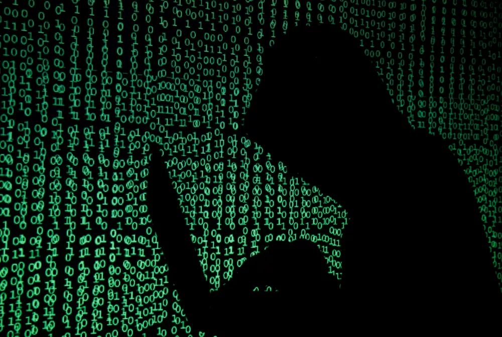 A hooded man holds a laptop computer as cyber code is projected on him in this illustration picture taken on May 13, 2017. Capitalizing on spying tools believed to have been developed by the U.S. National Security Agency, hackers staged a cyber assault with a self-spreading malware that has infected tens of thousands of computers in nearly 100 countries. REUTERS/Kacper Pempel/Illustration / Foto: Kacper Pempel