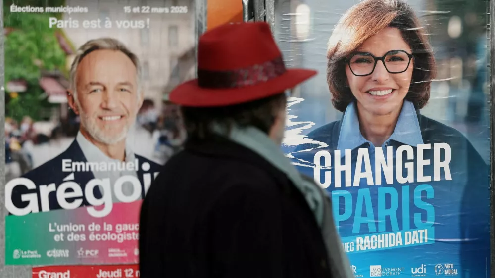 FILE PHOTO: A man looks at posters of Paris mayoral election candidates Emmanuel Gregoire, Socialist party candidate and head of the "left-wing coalition" list (La Gauche unie) and Rachida Dati, supported by Les Republicains (LR) and the MoDem parties, are seen on electoral campaign panel boards in Paris, France, March 6, 2026. REUTERS/Stephane Mahe/File Photo