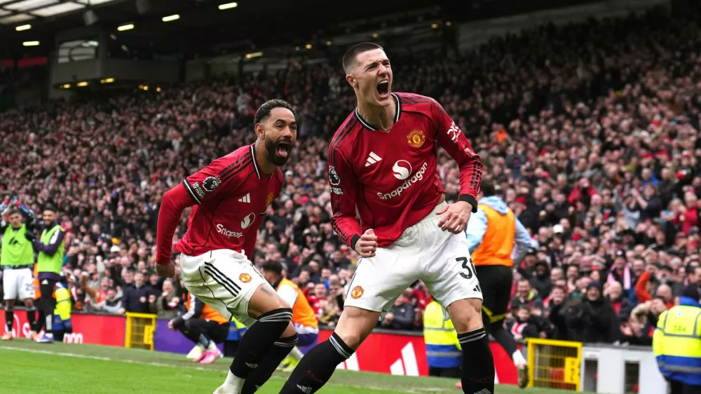 Manchester United's Benjamin Sesko, right, celebrates scoring their side's third goal of the game with team-mate Matheus Cunha during the Premier League match between Manchester United and Aston Villa, in Manchester, England, Sunday March 15, 2026. (Martin Rickett/PA via AP)