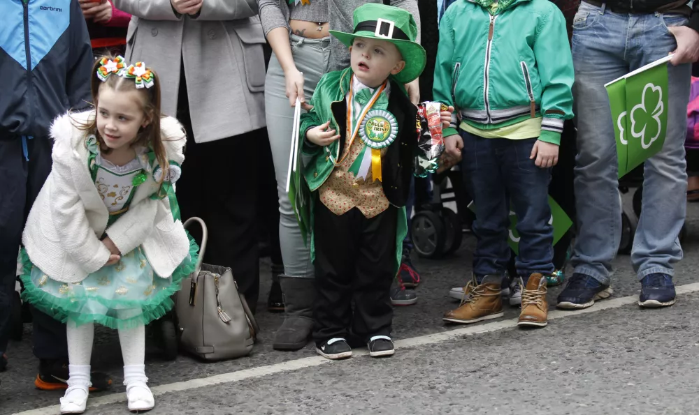 Children wait to catch a view of the St Patrick's day parade in the center of Belfast, Northern Ireland, Tuesday, March 17, 2015. (AP Photo/Peter Morrison)