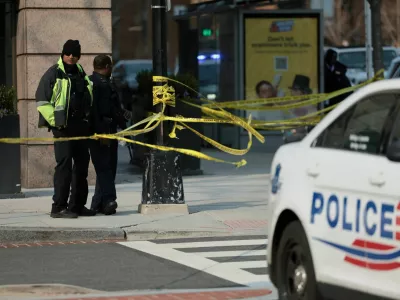 Law enforcement officers stand guard near a police vehicle, with yellow tape cordoning an area, on the scene of a bomb threat investigation in Washington, D.C., U.S., March 13, 2026. REUTERS/Jessica Koscielniak