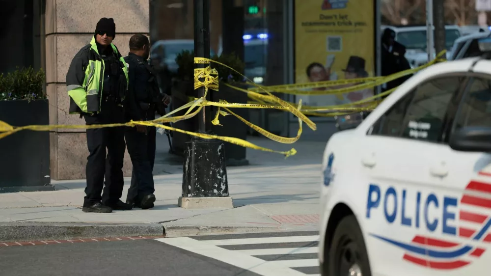 Law enforcement officers stand guard near a police vehicle, with yellow tape cordoning an area, on the scene of a bomb threat investigation in Washington, D.C., U.S., March 13, 2026. REUTERS/Jessica Koscielniak