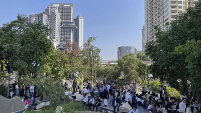 Office workers and residents who evacuated high-rise buildings after an earthquake wait in the shade along a canal in Bangkok, Friday, March 28, 2025. (AP Photo/Christie Hampton)