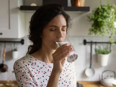 Pure pleasure. Thirsty millennial female drink swallow cool clear mineral aqua from glass at home kitchen feel delight. Young woman enjoy crystal filtered potable water with closed eyes relieve stress