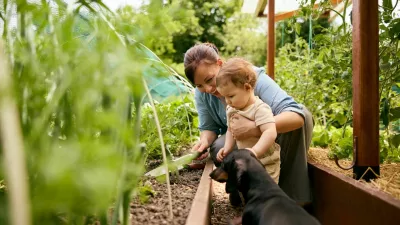 A mother and child explore an organic garden, embracing nature and agrotechnology in a green greenhouse. / Foto: Alextn