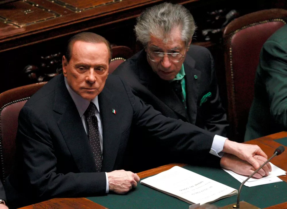 FILE PHOTO: Italian Prime Minister Silvio Berlusconi (L) holds League North Party leader Umberto Bossi's hand during a finance vote at the parliament in Rome on November 8, 2011. REUTERS/Tony Gentile/File Photo