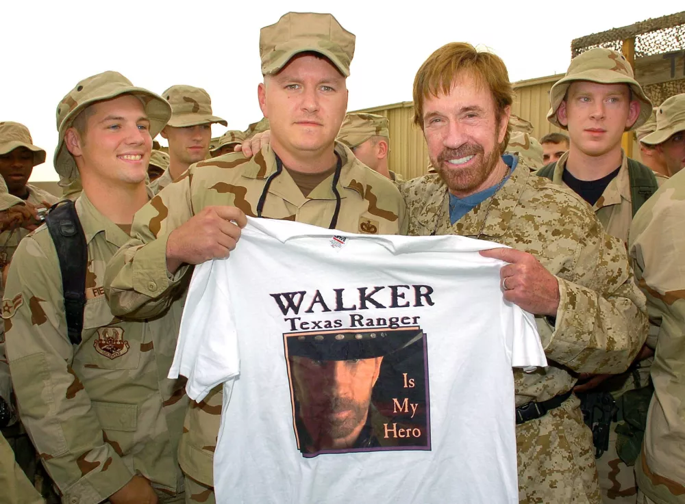 FILE PHOTO: Actor and martial artist Chuck Norris (R) holds up a t-shirt presented by USAF TSgt. Mike Haddock of Florence, Alabama, during a meet-the-troops stop at Ali Al Saleem Air Base, Kuwait October 29, 2006. Norris, best known for his role as Walker, Texas Ranger, is on a week-long USO tour to boost morale among US troops in the region.  EDITORIAL USE ONLY  REUTERS/USO/Mike Theiler/HO/File Photo / Foto: Mike Theiler